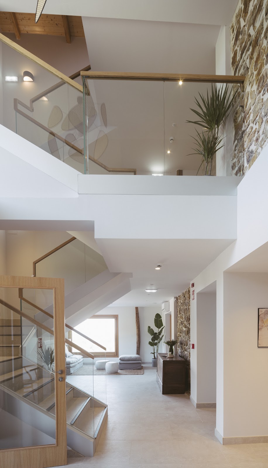 Escalera interior blanca con barandilla de madera